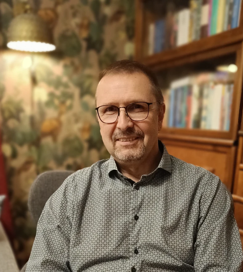 Psykoterapeutti Sami Somiska vastaanotollaan Porvoossa, taustalla lukulamppu ja kirjahylly.
